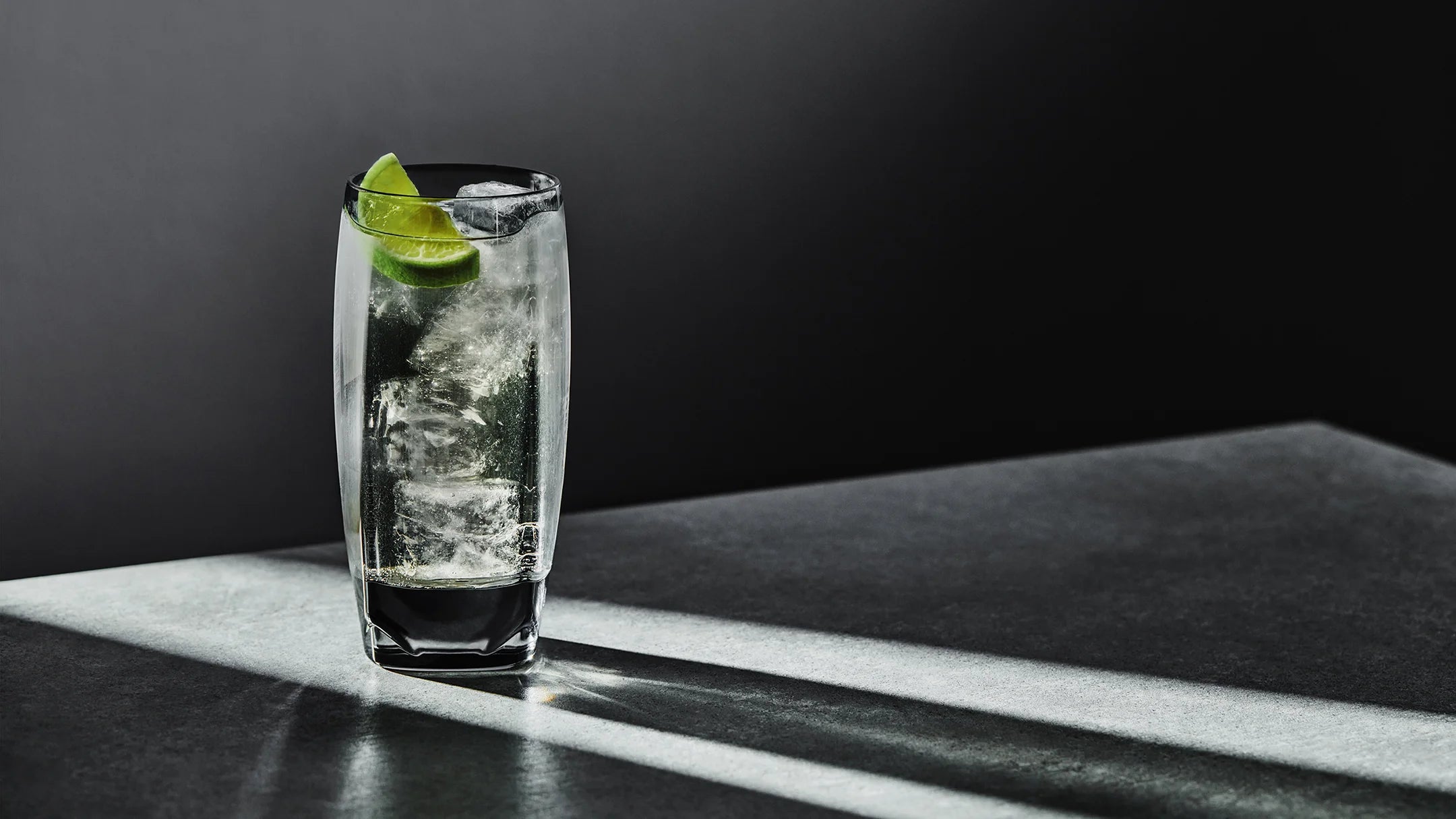 A full highball glass, namely our grey Vawe, with a spicy whisky ginger and lime cocktail.