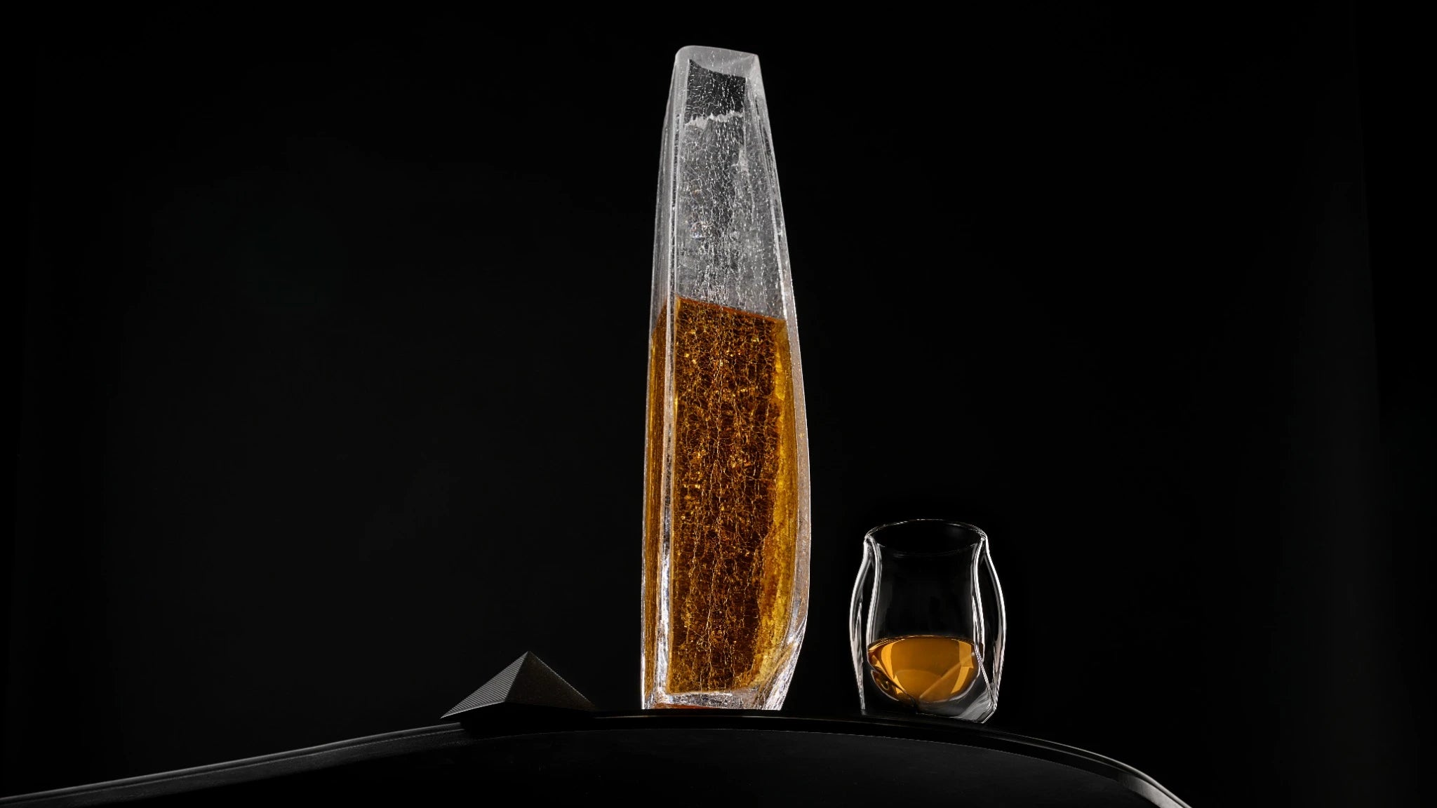 A panoramic shot of the Raif Whisky Decanter - Crackle Edition with whisky shot next to the Norlan Whisky Glass (Clear). A perfect pairing.