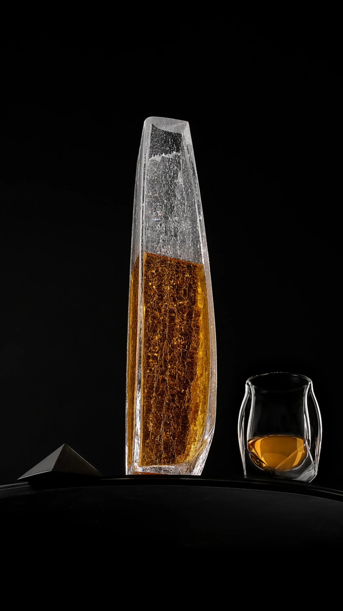 A panoramic shot of the Raif Whisky Decanter - Crackle Edition with whisky shot next to the Norlan Whisky Glass (Clear). A perfect pairing.