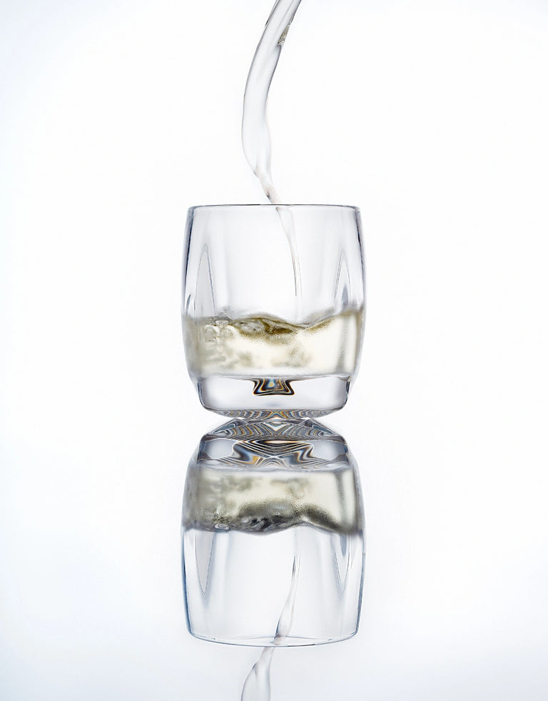 Norlan Rauk Heavy Tumbler 250 mL (Clear) with whisky being poured, reflected on a light background.